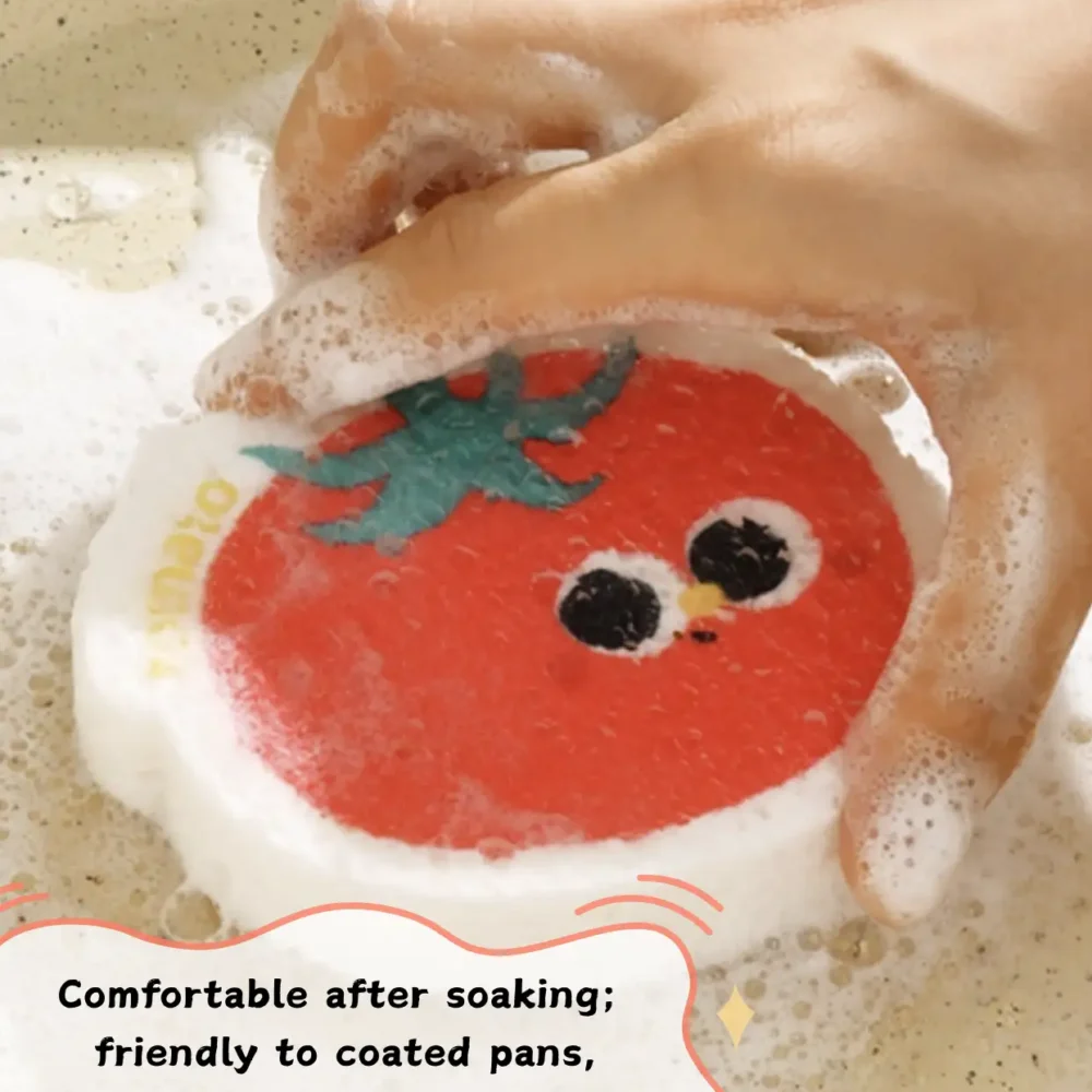 Tomato-shaped cellulose sponge creating rich foam while washing dishes
